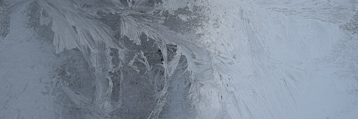 Vereiste Fensterscheibe mit Eiskristallen im Detail