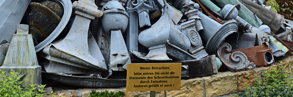 Ein Haufen Metallschrott als Kunstwerk liegt vor einer Metallwerkstatt im Erzgebirge