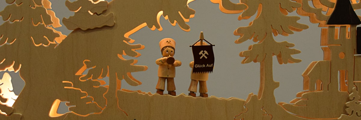 Schwibbogen Bergmann – Bergmänner mit Trompete und „Glück Auf“-Fahne in Nahaufnahme