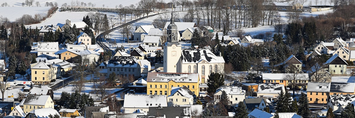 Blick auf den verschneiten Ortskern Großwaltersdorf von einem Berg